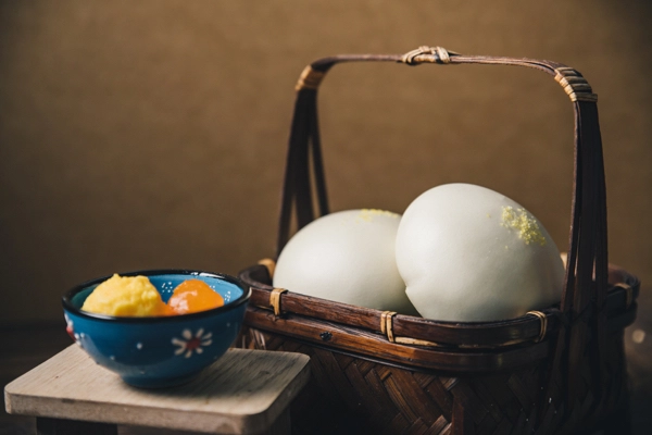 孔子饅頭【子予-金沙奶黃包】特寫，內餡使用鹹蛋黃的金沙翻砂效果，紅亮油潤，口感鹹甜。